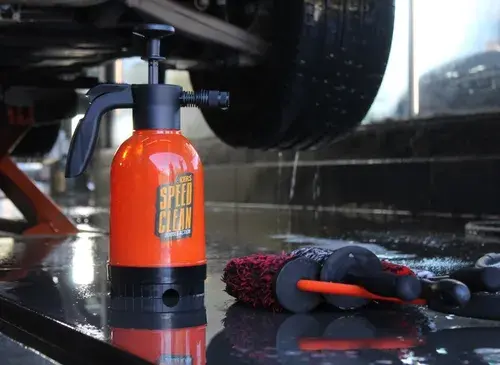 Pulverizador Kers Speed Clean 3 em 1 sendo utilizado em ambiente de estética automotiva, abaixo de um carro durante procedimento de lavagem profissional.
