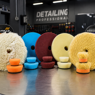 Boinas de polimento de diversos materiais para diferentes etapas de polimento. Marca Mills Automotive. Ao fundo ambiente profissional de estética automotiva.