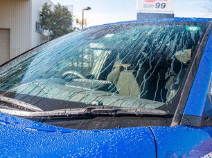 Para-brisa de carro azul repelindo água numa lavagem