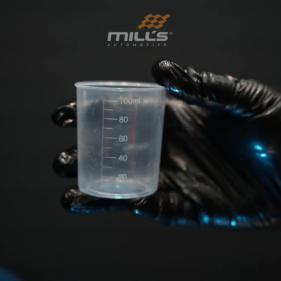 Profissional de estética automotiva usando luvas nitrílicas segura um copo graduado para realizar a diluição correta de um produto químico, garantindo uma aplicação segura e eficiente.