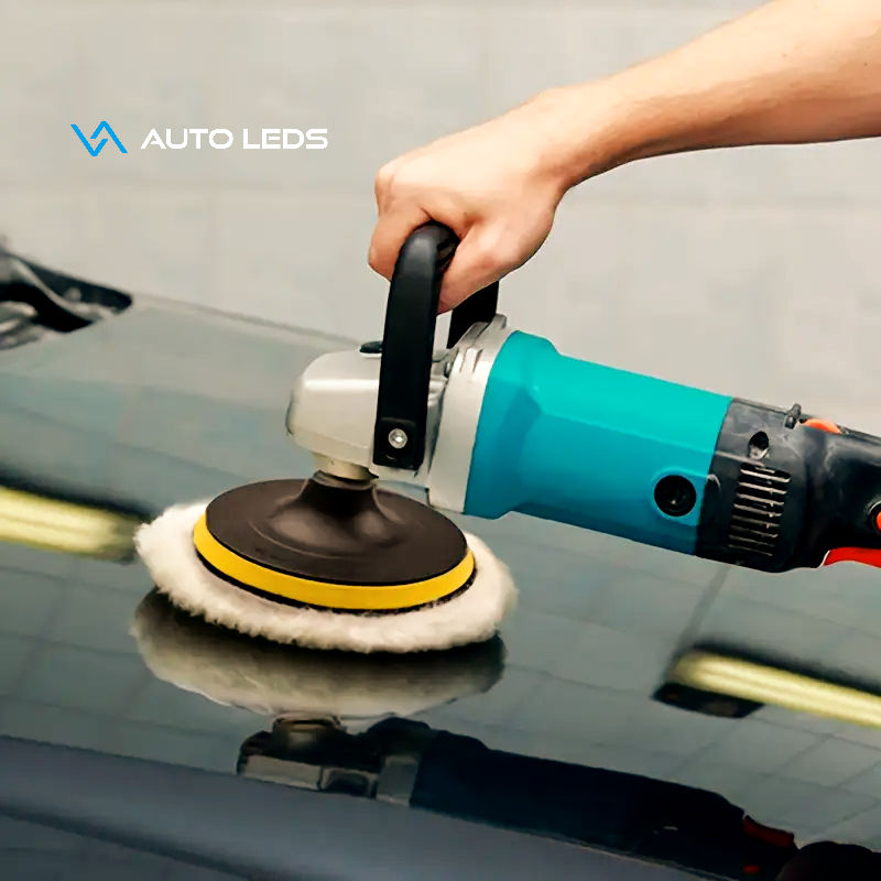 Profissional de estética automotiva realizando polimento com boina de lã híbrida em capô de carro, destacando o brilho e o acabamento da pintura.