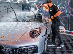 homem lavando um carro importado em uma estética automotiva premium