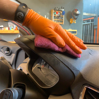 Realizando a limpeza no painel do carro com o pano e APC Mill's Fleet Wash