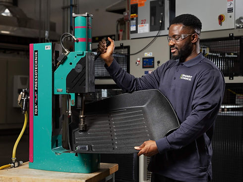 A man using manufacturing machinery to modify a Smart Choice floor mat.