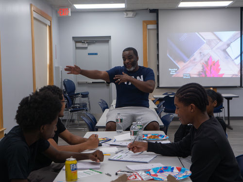 Mentor leading discussion with teens around a table