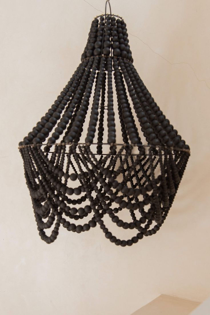 Sali chandelier featuring black wooden beads, exuding elegance and charm in a stylish lighting fixture.