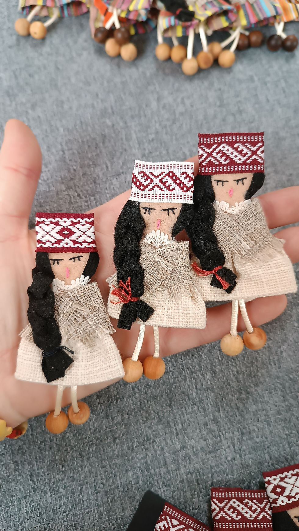 Sīktēls: Pespraudīte- tautu meita. Melni  mati. Balti svārki