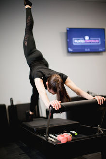 Pilates  instructors using a reformer pilates machine