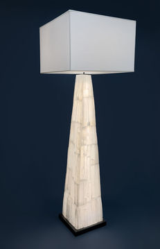 Selenite Pyramid Floor Lamp, This floor lamp features a pyramid-shaped selenite base that glows from within, revealing the stone’s natural translucence. Paired with a clean, modern shade, it brings a warm, sculptural elegance to any space.

Shown at 72"H