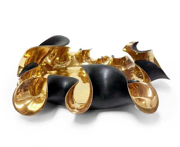 Corin ceramic centerpiece featuring an expressive sculptural form with flowing ribbon-like edges, matte black exterior, and hand-applied 22k gold interior. A luxury handcrafted decorative bowl designed as a statement centerpiece for contemporary interiors.