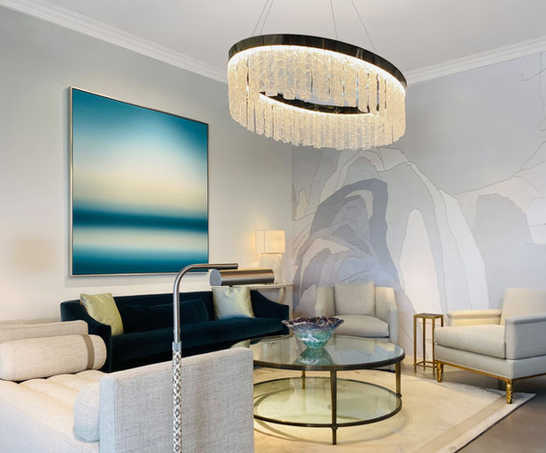 Le Calais fused glass chandelier suspended above a luxury seating vignette. Handcrafted textured glass panels cascade from a circular metal frame, creating a luminous centerpiece that combines artisan craftsmanship, sculptural form, and sophisticated ambient lighting.
