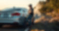 man leaning up against his car waiting on the side of the road with his car steaming .jpg