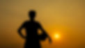 Silhouette man standing holding football soccer with sunset background.jpg