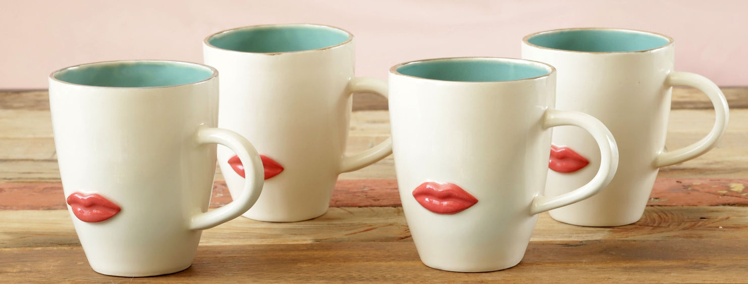 Four white mugs with red lip prints and blue interiors