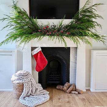 a festive foraged fireplace garland with giant christmas stocking