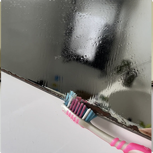 a toothbrush scrubbing a mirror with bad mirror rust aka desilvering to repair it