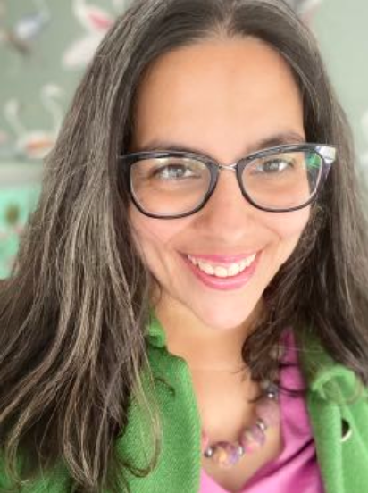 lady with glasses smiling at the camera