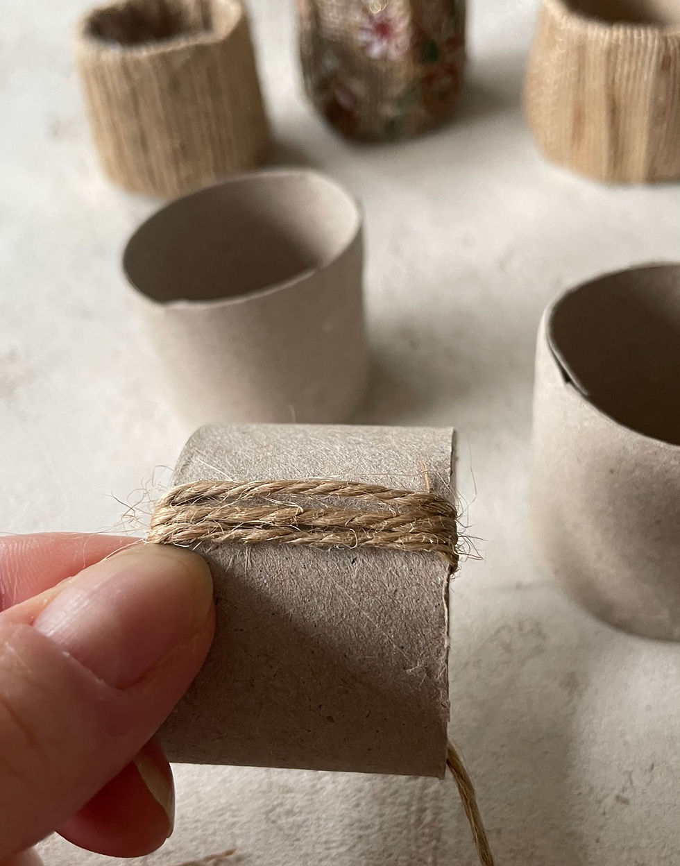 String wrapping around an empty toilet roll to make a rustic napkin ring
