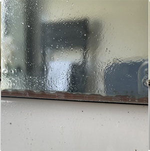 mirror desilvering with rust along the bottom from water penetration