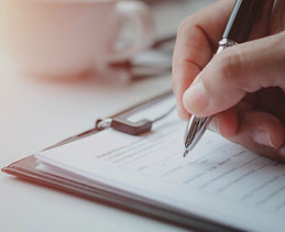 Close-up of writing on a clipboard during clinical documentation