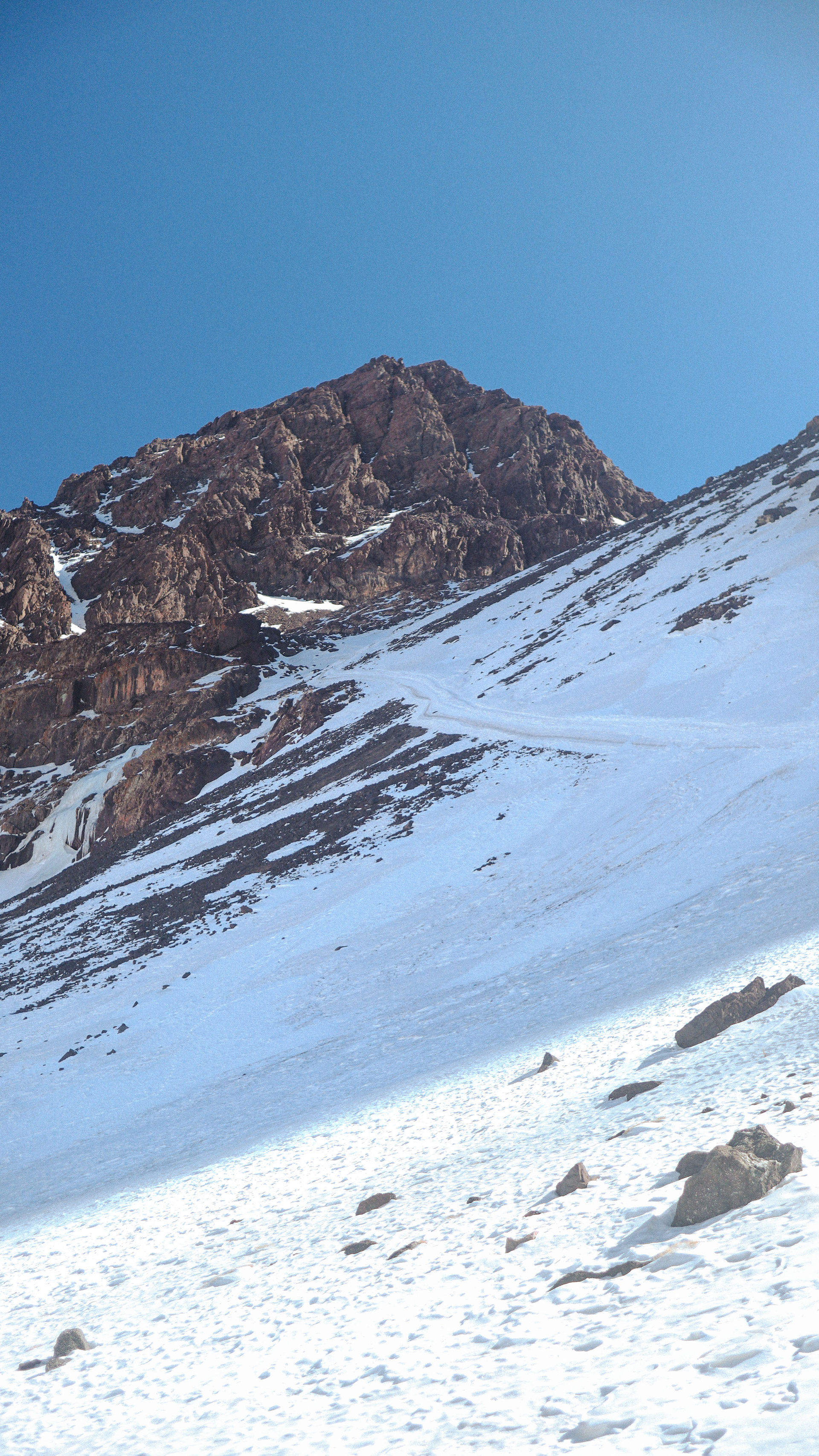 Besneeuwd wandelpad langs een berg