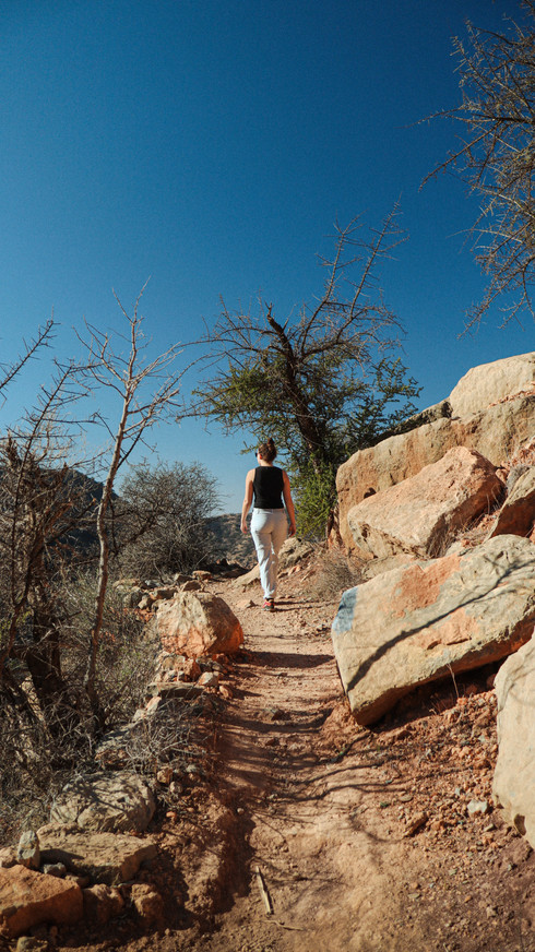 Een wandelaar op een pad met rotsen