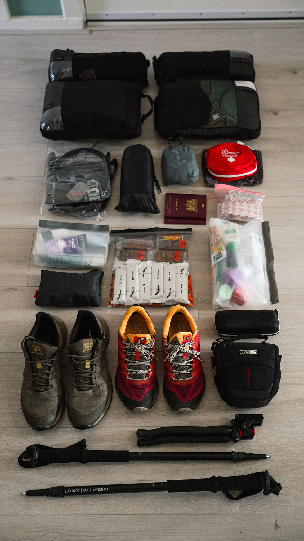 Overzicht van de complete inhoud van 2 backpacks georganiseerd voor een wandelvakantie