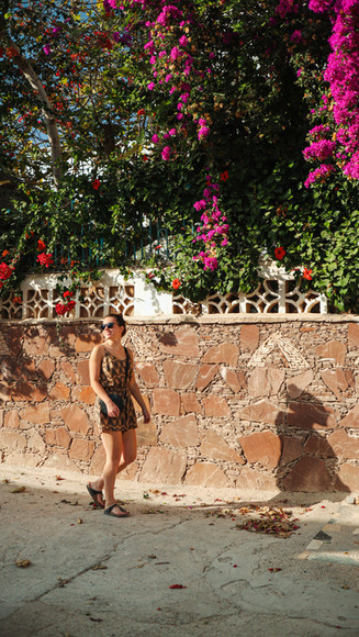 Een persoon lopend over straat met overhangende bloemen