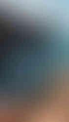 Wandelaar zittend op een rots uitkijkend op de zee