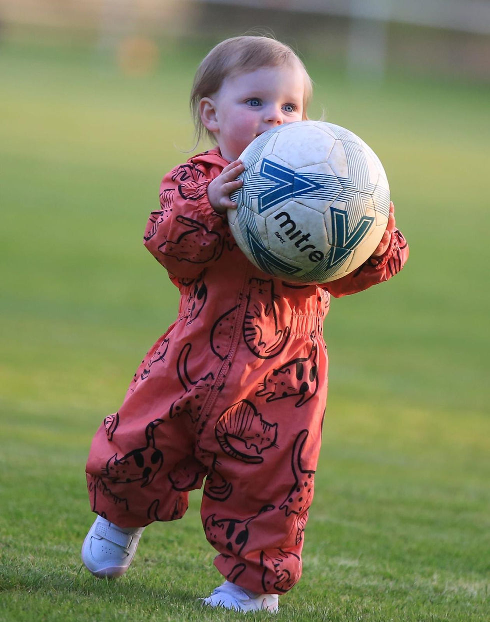 A young child with a football at a 4-4-2 Sports event