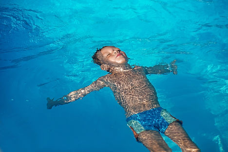 Happy Kid Playing In Blue Water Of Swimming Pool..jpg