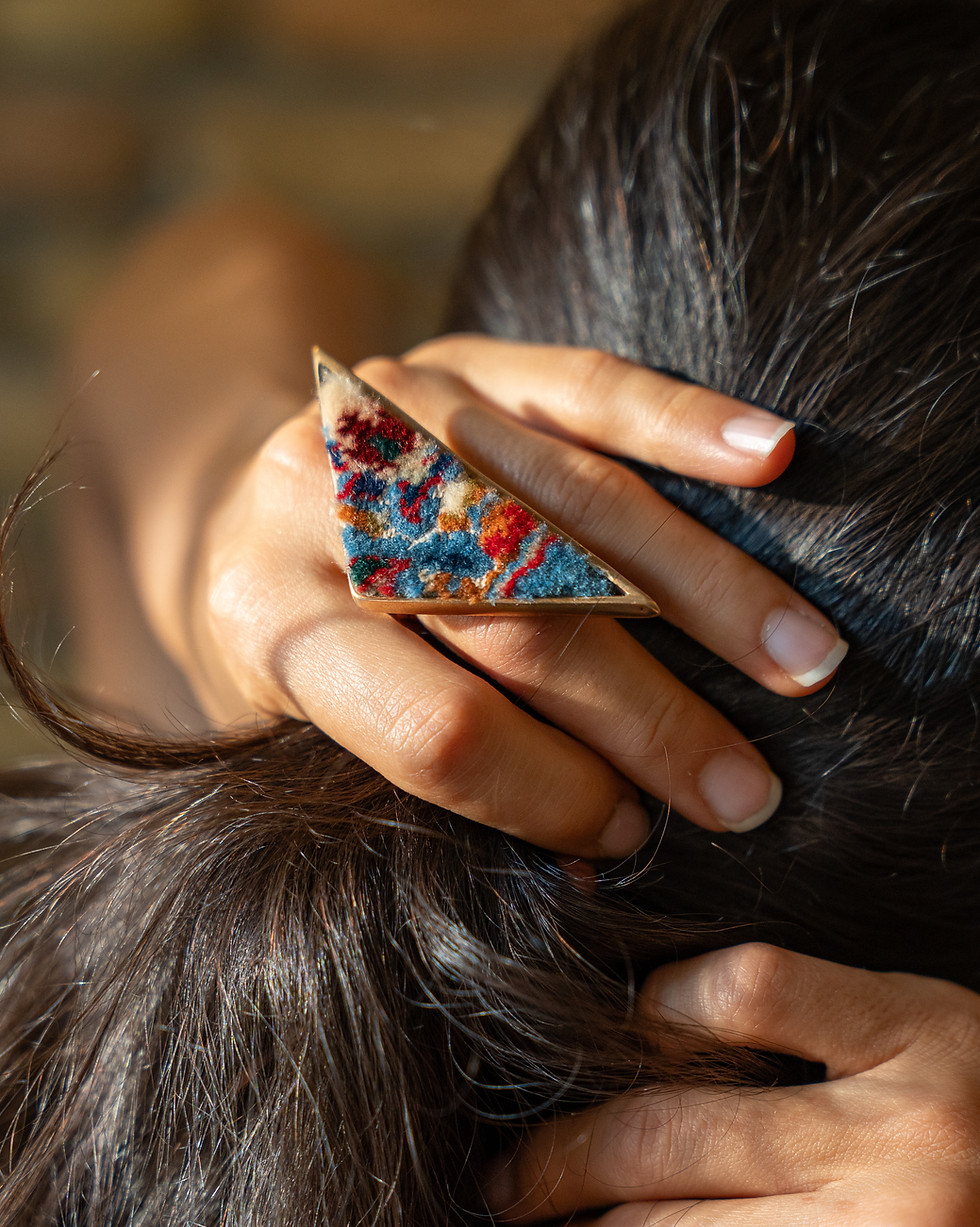Handcrafted triangular carpet ring by Rawa, worn while styling hair