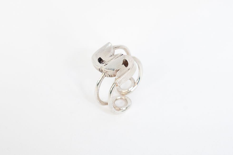 Twine ring by Rawa, an open sterling silver band with two forms wound together, on a white background
