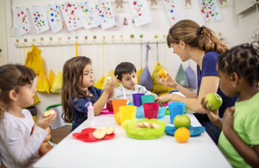 Children eating at a snack table in a classroom