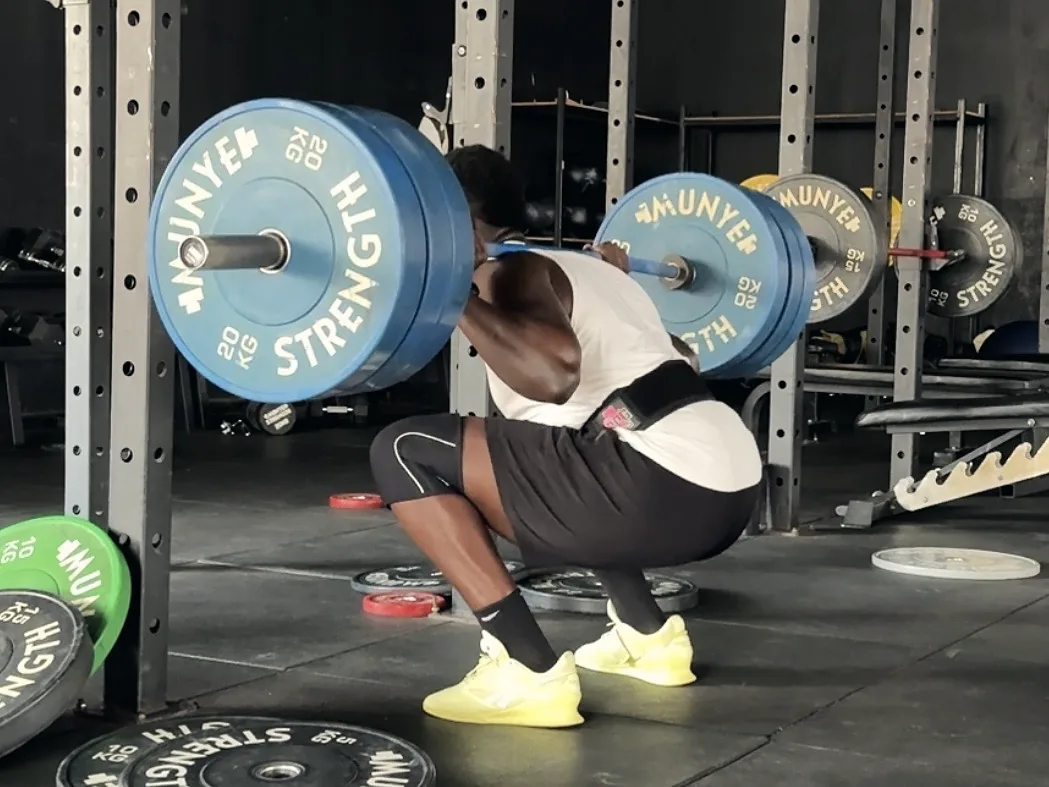 Athlete at the bottom of a heavy back squat in a power rack