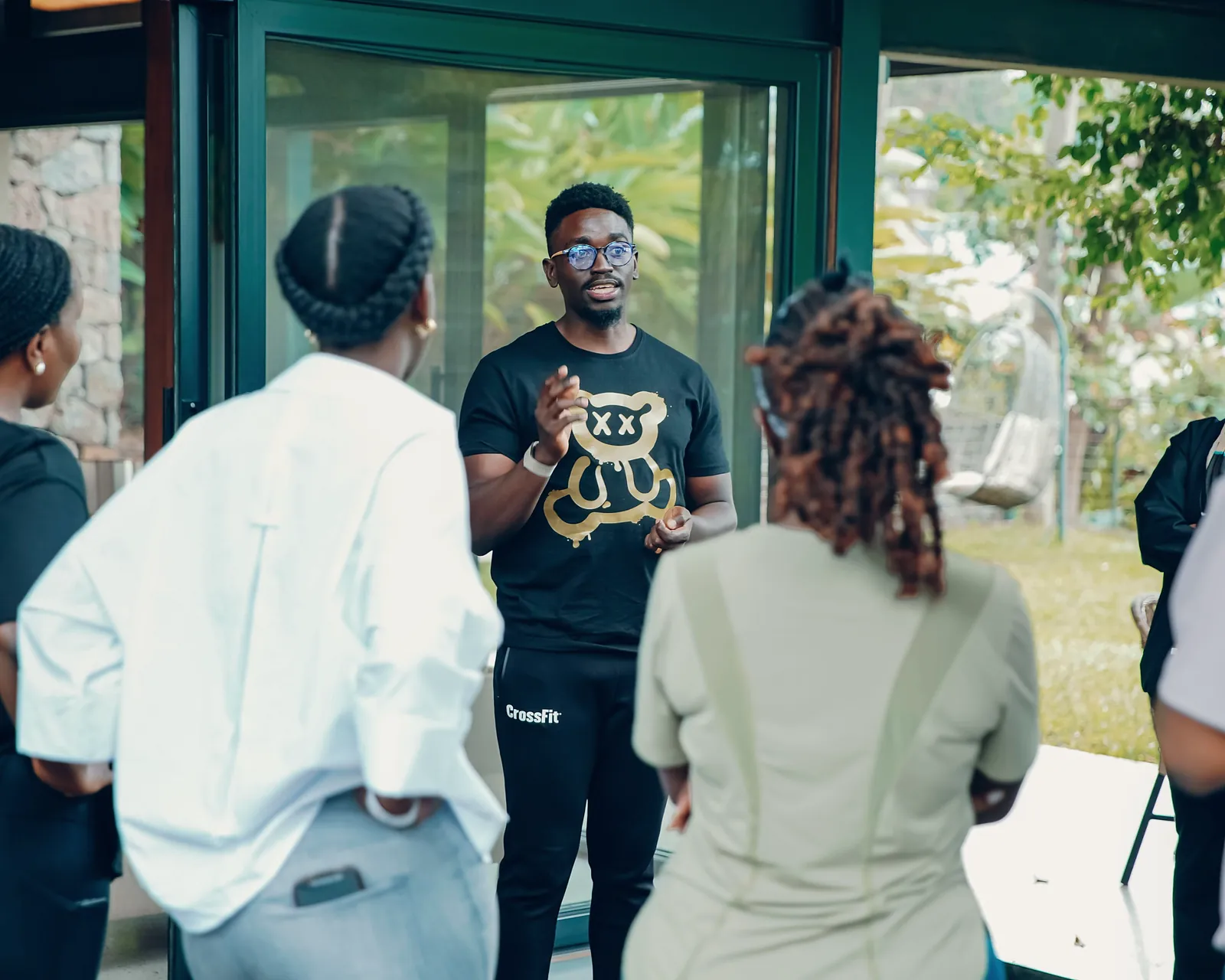 Coach speaking to a small group by a garden window