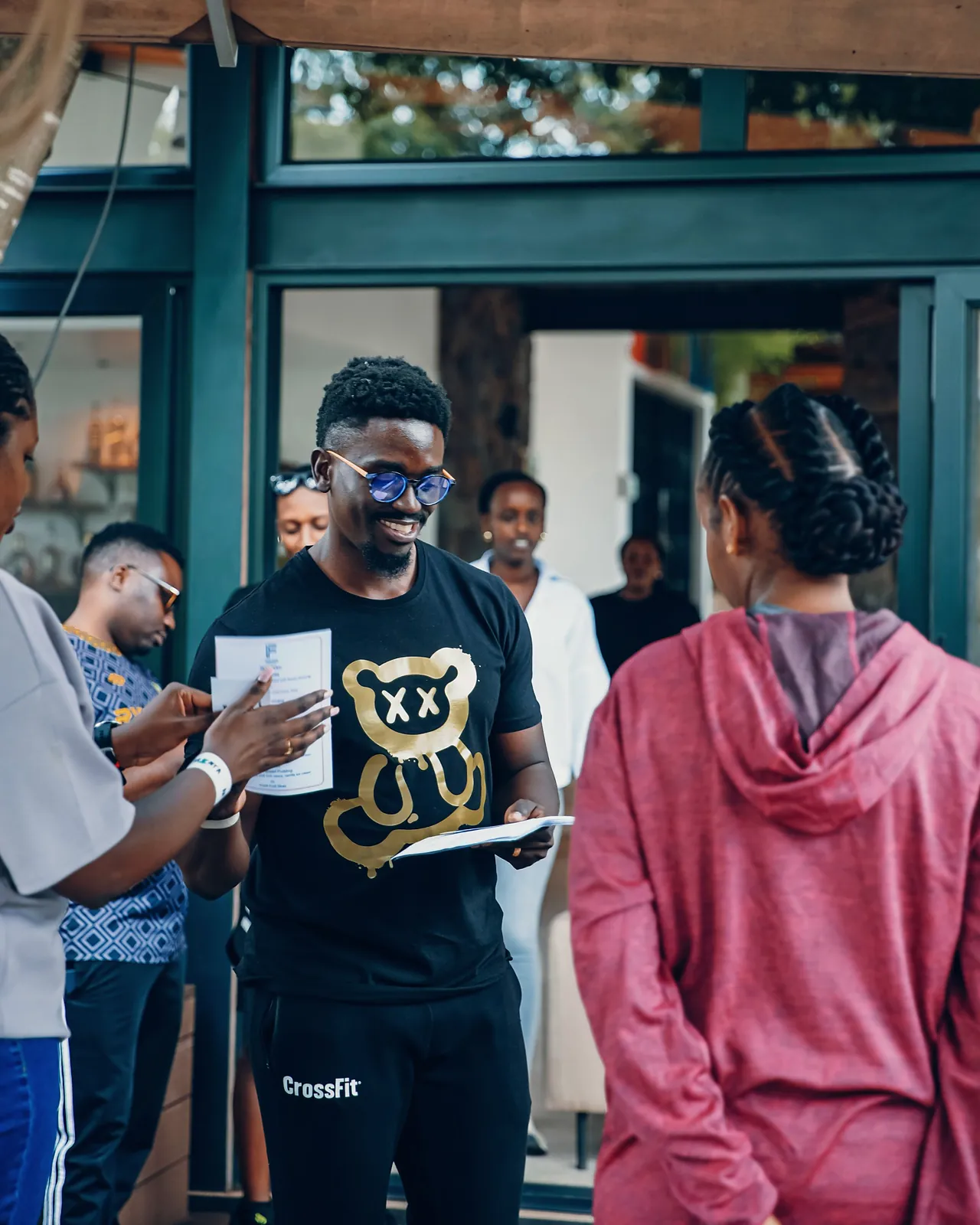 Coach smiling as he hands out session sheets to a team at a wellness day