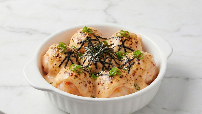 Indulge in the rich and savory Baked Lobster Ball Mentai. Premium lobster balls are baked with a creamy, torched mentai sauce and topped with nori, creating a modern and irresistible flavor experience. Prep Time: 10 Minutes Cook Time: 8 Minutes Servings: 2 Ingredients Main 1 pack Seafoodking Lobster Balls (about 6-8 pieces). 1 tbsp unsalted butter, melted. Mentai Sauce 4 tbsp Japanese mayonnaise (Kewpie mayo recommended for best flavor). 1.5 tbsp chili sauce (sriracha or similar). 1 tsp sesame oil. A pinch of sugar (optional, to balance the heat). Toppings Shredded nori (roasted seaweed). 1 stalk scallion, finely sliced. Tobiko (flying fish roe) for an extra premium touch (optional). Instructions Preheat & Prep Preheat your oven to 200°C (390°F) or set your air fryer to the same temperature. Lightly brush a small, oven-safe dish with the melted butter. Arrange Place the Seafoodking Lobster Balls in a single layer in the prepared dish. You can slightly score the top of each ball to help the sauce adhere better. Make the Sauce  In a small bowl, whisk together the Japanese mayonnaise, chili sauce, sesame oil, and sugar until smooth and well-combined. The color should be a creamy light orange. Coat & Bake Generously spoon the mentai sauce over each lobster ball, ensuring the top is fully covered. Bake for 5-8 minutes. The sauce should be bubbly, and the tops should have attractive, slightly charred or browned spots (a "torched" look). Garnish & Serve  Remove from the oven carefully. While still hot, sprinkle with the shredded nori and sliced scallions. If using, add a small dollop of tobiko on top. Serve immediately while warm and creamy.