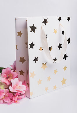 beautiful-pink-water-lily-near-white-shopping-bag-with-golden-star-shape-white-background.