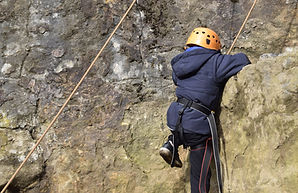 A person climbing up a rock face.