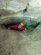 A woman smiling as she comes out a cave