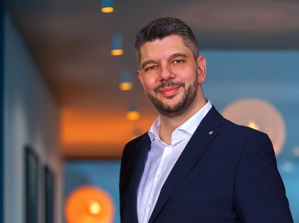 Andrei Raileanu portrait photo in a suite in an office environment.