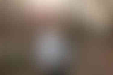 Pareja abrazándose durante su sesión de preboda en Mesa de los Santos, Bucaramanga. Ambos visten camisas blancas mientras se miran con ternura bajo un árbol iluminado por la luz suave del atardecer. Fotografía natural y emotiva capturada por Johan Rey, fotógrafo de bodas en Colombia.