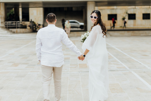Un fotografo captura una pareja de esposos frente a un edificio en Bucaramanga
