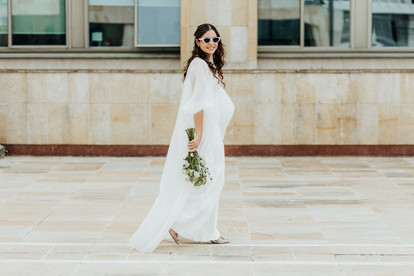 Un fotografo captura una pareja de esposos frente a un edificio en Bucaramanga