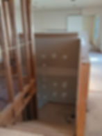 Interior stairwell landing under construction with drywall and timber post framing exposed.