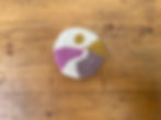 Handmade wool coaster with pink, purple, and yellow hills inspired by The Downs in Sussex.