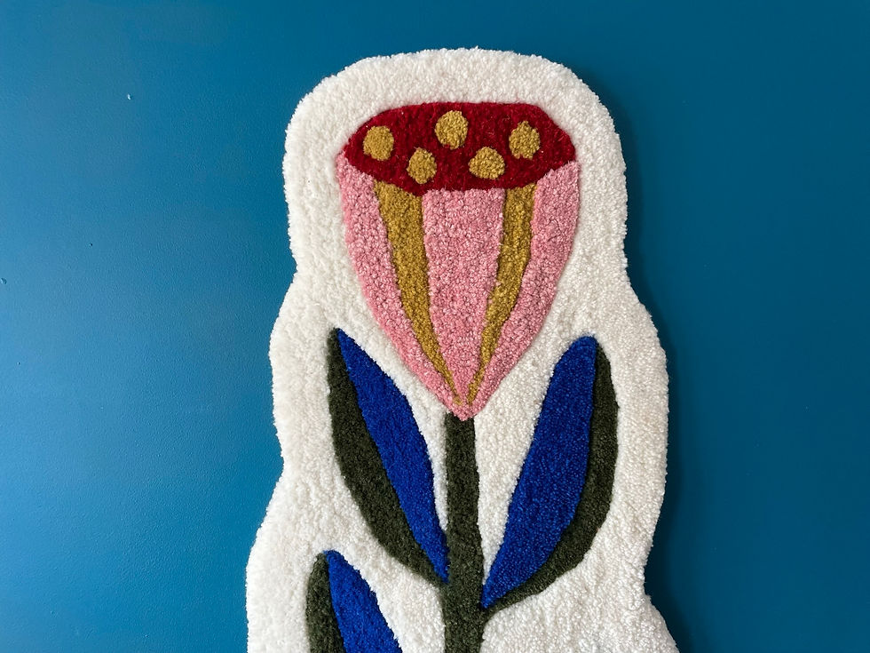 Hand-tufted wall hanging of stylised seed heads in rich, folk-inspired colours, soft textured surface, cork backing