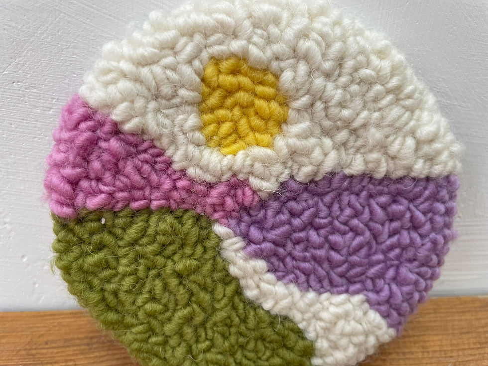 Thumbnail: Handmade wool coaster features a punch needle landscape of The Downs in Sussex, with rolling pink, purple, and green hills a
