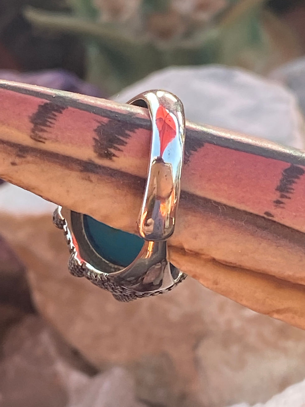 Thumbnail: Band view of a vibrant round turquoise ring in silver, highlighting the gemstone's smooth surface and ornate setting.